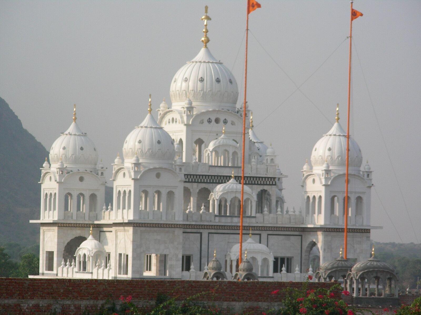 Paonta Sahib Gurudwara | Sikh Saints Paonta Sahib Gurudwara features beautiful white marble and orange flags, showcasing Sikh faith.